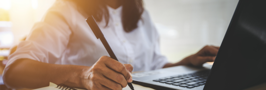 A woman writing on a notebook